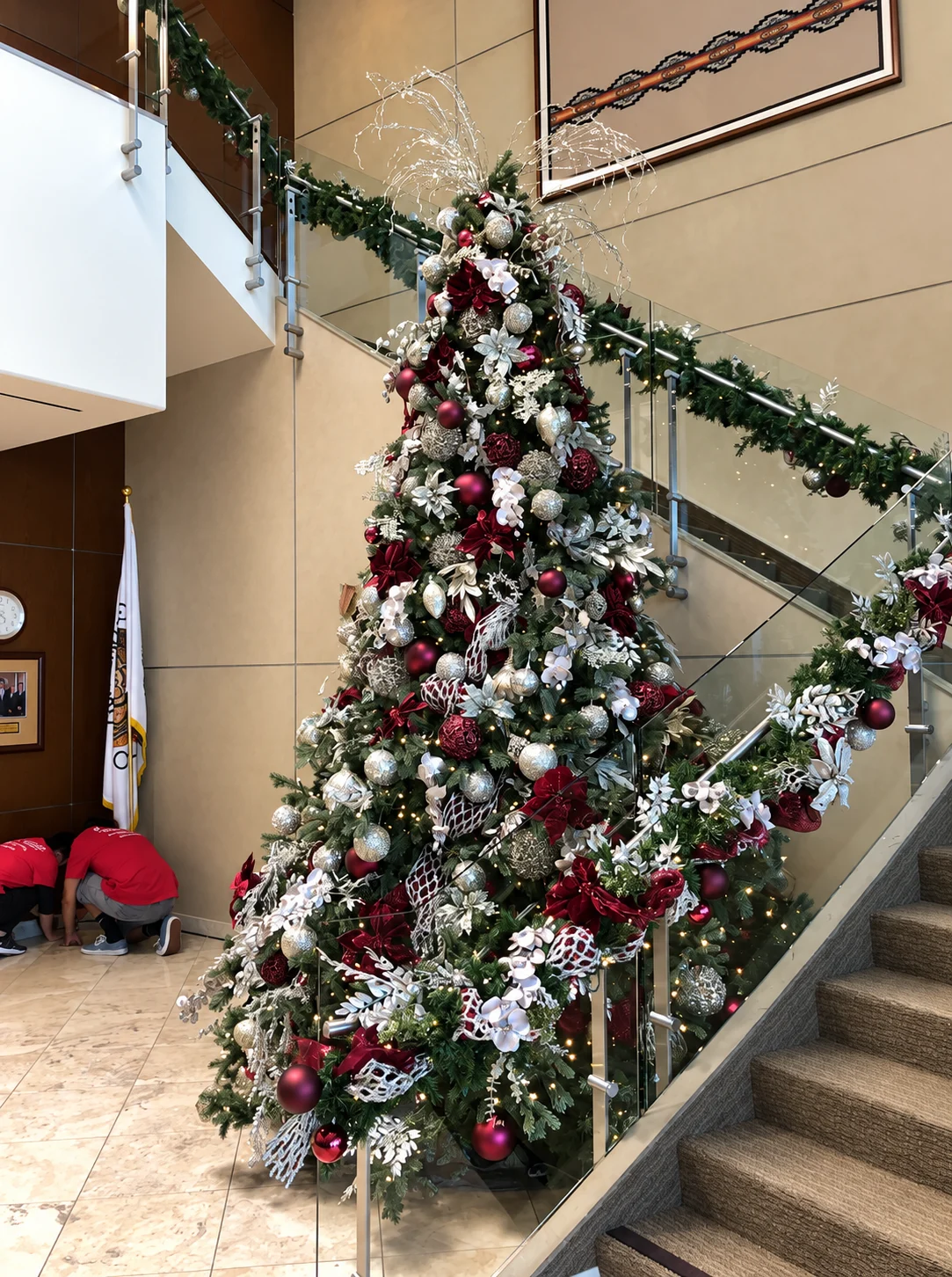 A towering tree and garland in a commercial lobby